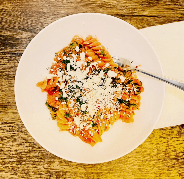 hummus pasta with tomatoes, spinach, and feta